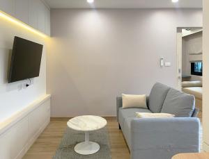 uma sala de estar com um sofá e uma televisão em Moon House BKK Room 3B em Amphoe Phra Khanong