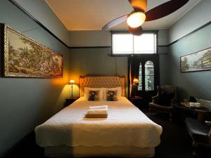 a bedroom with a bed and a ceiling fan at The Boutique Hotel Blue Mountains in Blackheath