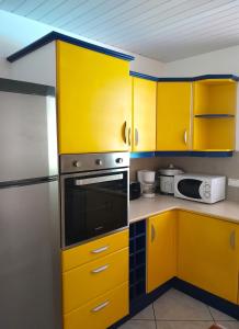eine Küche mit gelben Schränken und einem Kühlschrank in der Unterkunft MOOREA VILLA KAHAIA in Teavaro
