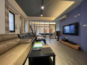 a living room with a couch and a tv at FengJia Pleasure Life 1 in Taichung