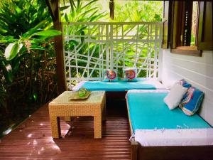 - une terrasse couverte avec une table, un canapé et une table sidx sidx dans l'établissement Titalee Lodge 3 Villas autour d'une piscine, à Saint-François