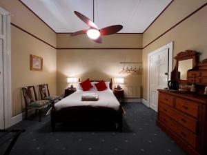 1 dormitorio con 1 cama y ventilador de techo en The Boutique Hotel Blue Mountains, en Blackheath