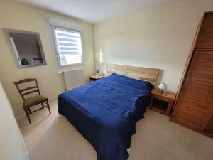 ein Schlafzimmer mit einem blauen Bett und einem Stuhl in der Unterkunft Villa Wimereux, 6 pièces, 8 personnes - FR-1-675-17 in Wimereux