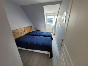 małą sypialnię z łóżkiem z niebieskim kocem w obiekcie Maison 4 ch. à Wimereux, jardin, wifi, garage, idéal pour familles - FR-1-675-17 w mieście Wimereux