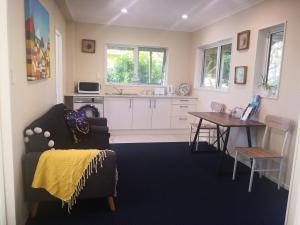 een keuken met een bank en een tafel in een kamer bij Rose Room in Auckland