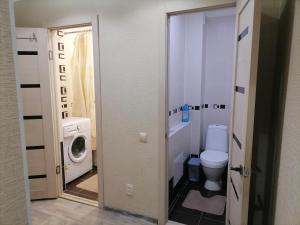 La salle de bains est pourvue de toilettes et d'un lave-linge. dans l'établissement Квартира на Бр Жубановых 283 корпус 1, à Aqtöbe