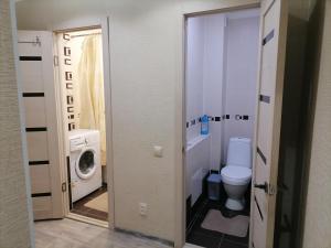 ein Badezimmer mit einem WC und einer Waschmaschine in der Unterkunft Квартира на Бр Жубановых 283 корпус 1 in Aqtöbe