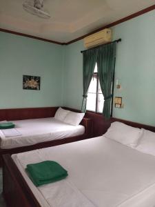 two beds in a room with a window at Family Tanotebay Resort in Ko Tao