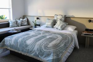 1 dormitorio con 1 cama grande con manta azul y blanca en Beach Road Hotel en Sídney