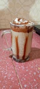 a cup of coffee sitting on a table at Sweety's Residency in Port Blair