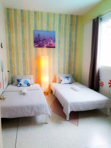 Habitación con 2 camas en una habitación en Baan Nampetch Hostel, en Bangkok