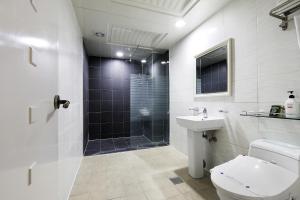 a bathroom with a shower and a toilet and a sink at White Tourist Hotel in Jeonju