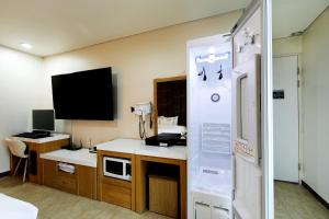 Zimmer mit einem Schreibtisch und einem TV in einem Zimmer in der Unterkunft White Tourist Hotel in Jeonju