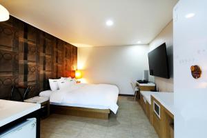 a hotel room with a bed and a tv at White Tourist Hotel in Jeonju