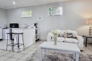 ein Wohnzimmer mit einem weißen Sofa und einem Tisch in der Unterkunft Herbie's Hideout: 1 Bed Cottage W/ View and Pool in Bothaʼs Hill