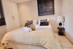 ein Schlafzimmer mit einem Bett mit zwei Kissen darauf in der Unterkunft Herbie's Hideout: 1 Bed Cottage W/ View and Pool in Bothaʼs Hill