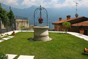 a garden with a large stone planter in the grass at Villa Seriola in Limone sul Garda