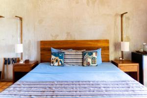 a bedroom with a bed with blue sheets and pillows at LAGOON SPECIAL Suite: Bikes & Kayaks! in Bacalar