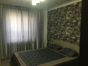 - une chambre avec un lit orné d'une fresque murale dans l'établissement Квартира на Бр Жубановых 283 корпус 1, à Aqtöbe