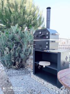 a black stove in a yard with a fence at Stilvolle Villa mit Strandlage in Didim