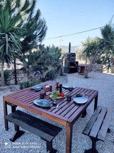a wooden picnic table with plates of food on it at Stilvolle Villa mit Strandlage in Didim