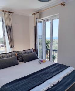 a bedroom with a large bed with large windows at Stilvolle Villa mit Strandlage in Didim