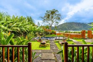 a garden with a pool and a fence at KINTAMANI Paradise Villa in Kintamani
