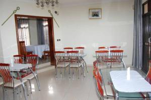 a dining room with tables and chairs in a room at Step Town in Kigali