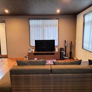 sala de estar con sofá y TV de pantalla plana en Pool Villa Sesoko jima, en Motobu