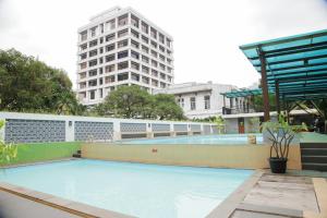 an empty swimming pool with a tall building in the background at Grand Inna Medan in Medan