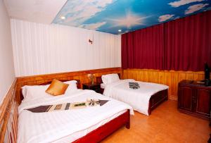 een slaapkamer met 2 bedden en een rood gordijn bij Hà Giang Hotel Sapa in Sa Pa