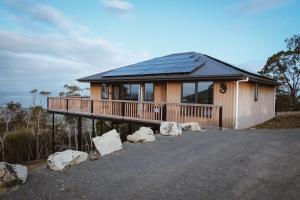 una casa con terraza con paneles solares en Mount Rumney Escapes Seaview House 1 - Possum House, en Mount Rumney