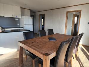 mesa de comedor con sillas y cocina en Mount Rumney Escapes Seaview House 1 - Possum House en Mount Rumney