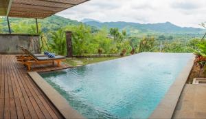 a pool at a villa with mountains in the background at Sumberkima Resort in Pemuteran
