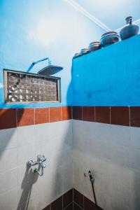 a corner of a bathroom with a window and pots at Agus Hidden Homestay - Banjar Sweet Village in Banyuwangi