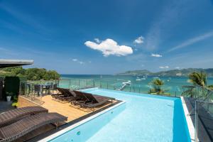 ein Swimmingpool mit Liegen und Blick aufs Wasser in der Unterkunft Patong Signature Boutique Hotel in Patong Beach