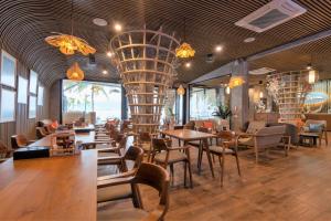 ein Restaurant mit Tischen und Stühlen und einem Kronleuchter in der Unterkunft Patong Signature Boutique Hotel in Patong Beach