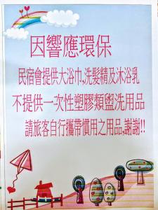 un cartel con escritura china en una pared con un arco iris en Bokelai B&B en Renai