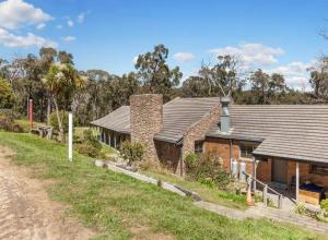 a house on the side of a dirt road at Harmonious One Bedroom Cabin in Wallan