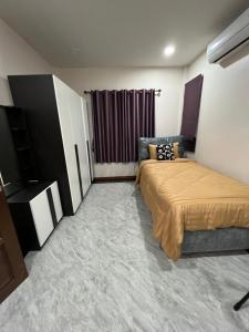 um quarto com uma cama e uma televisão em New Home Gบ้านเดี่ยวสร้างใหม่ ใกล้ทะเล ตัวเมืองระยอง em Ban Chak Phai