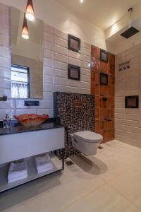 y baño con aseo, lavabo y espejo. en Glass Apartment, en Bangalore