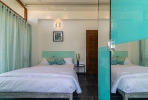 1 dormitorio con 2 camas y espejo en Glass Apartment, en Bangalore