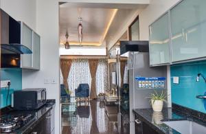 una cocina con armarios azules y blancos y fregadero en Glass Apartment, en Bangalore