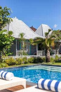 a house with a swimming pool in front of a house at Casa Batu Belig in Seminyak