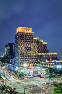 a large building in a city with traffic at night at Hampton by Hilton Zhuhai Gongbei Port in Zhuhai