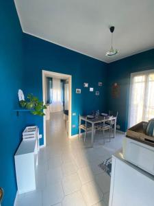 una cucina con pareti blu e tavolo e sedie di La casetta di Andreina a Sarzana