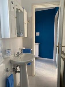 łazienka z umywalką i niebieskimi drzwiami w obiekcie La casetta di Andreina w mieście Sarzana