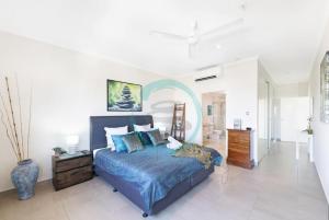 a bedroom with a large bed with a blue comforter at ZEN PINNACLE PENTHOUSE Darwin's Exclusive Zen Retreat in Darwin City in Darwin +47 photos