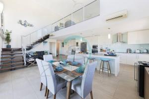 a kitchen and dining room with a table and chairs at ZEN PINNACLE PENTHOUSE Darwin's Exclusive Zen Retreat in Darwin City in Darwin