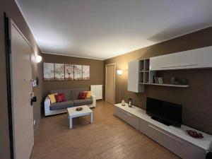 ein Wohnzimmer mit einem Sofa und einem TV in der Unterkunft La Maison di Gabriella e Alfredo in Edolo